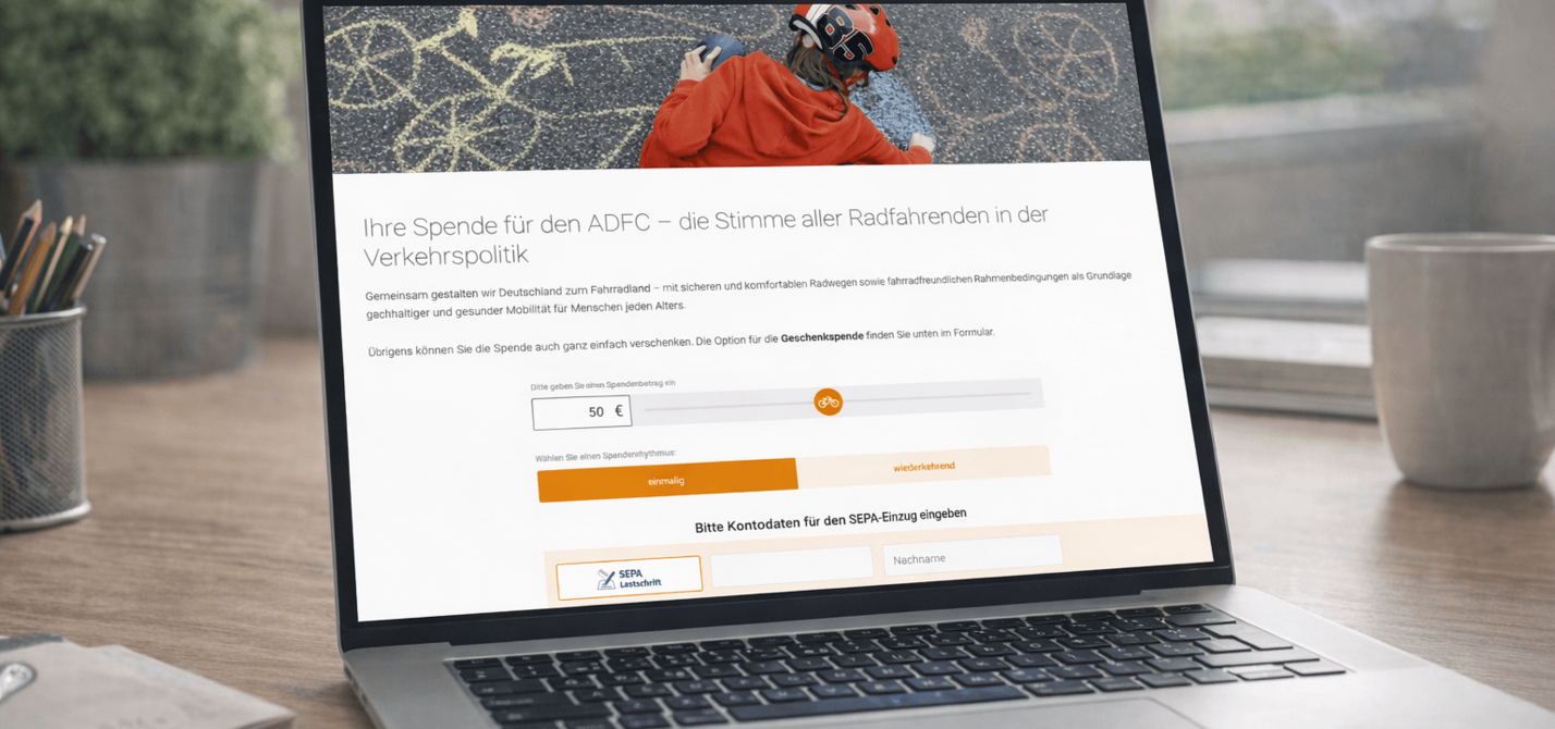 Spendenformular Desktopansicht Ein Laptop steht auf einem Tisch. Auf dem Bildschirm ist die Spendenseite des ADFC zu sehen.