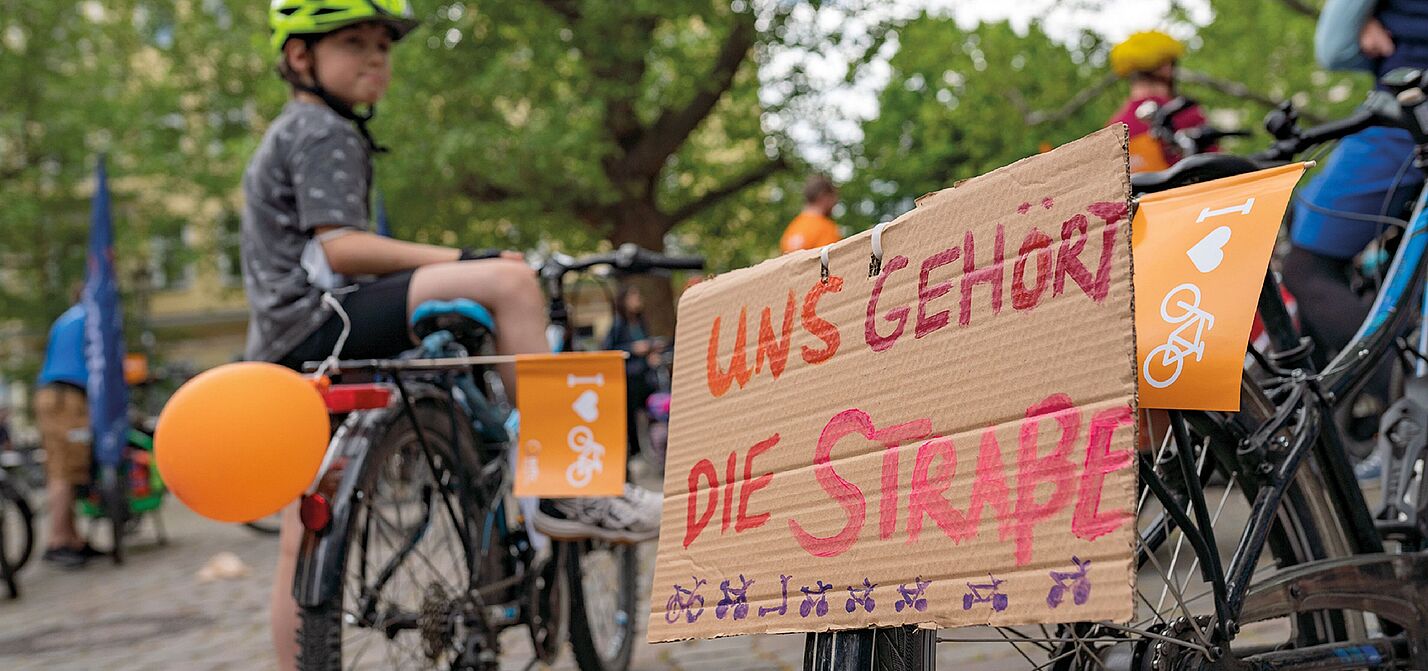 Kind mit Fahrrad und Protestschild