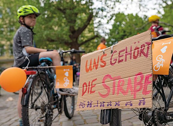 Kind mit Fahrrad und Protestschild